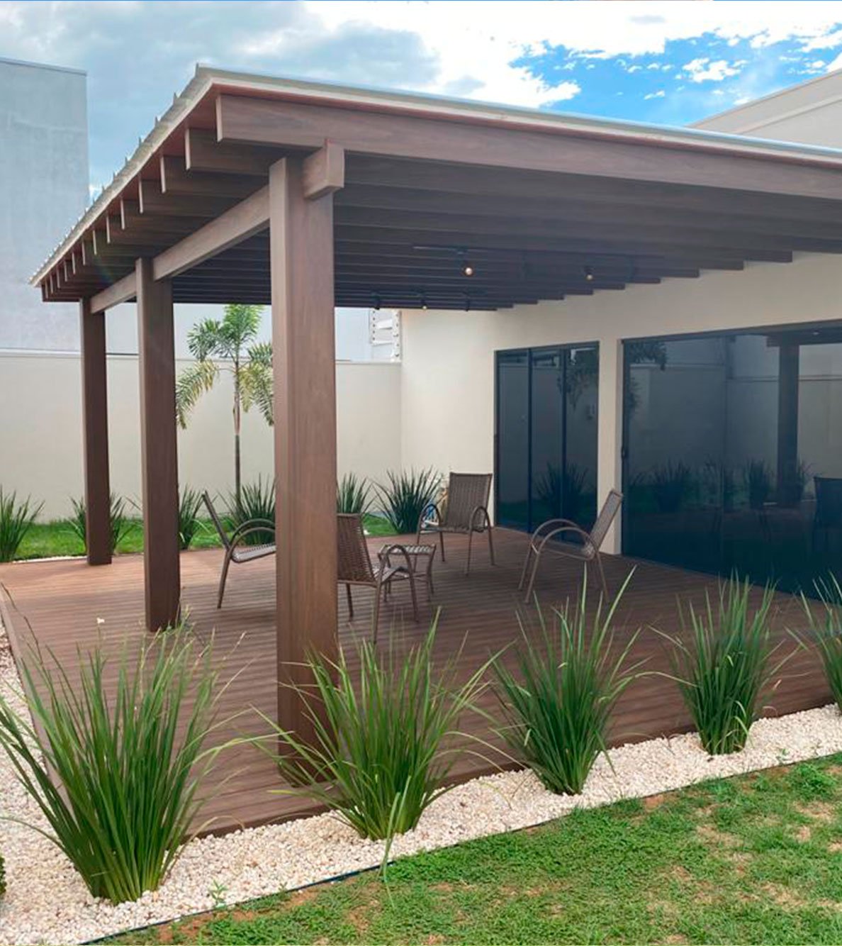 Pergolado Linha Prime sobre deck com paisagismo de pedras e gramíneas