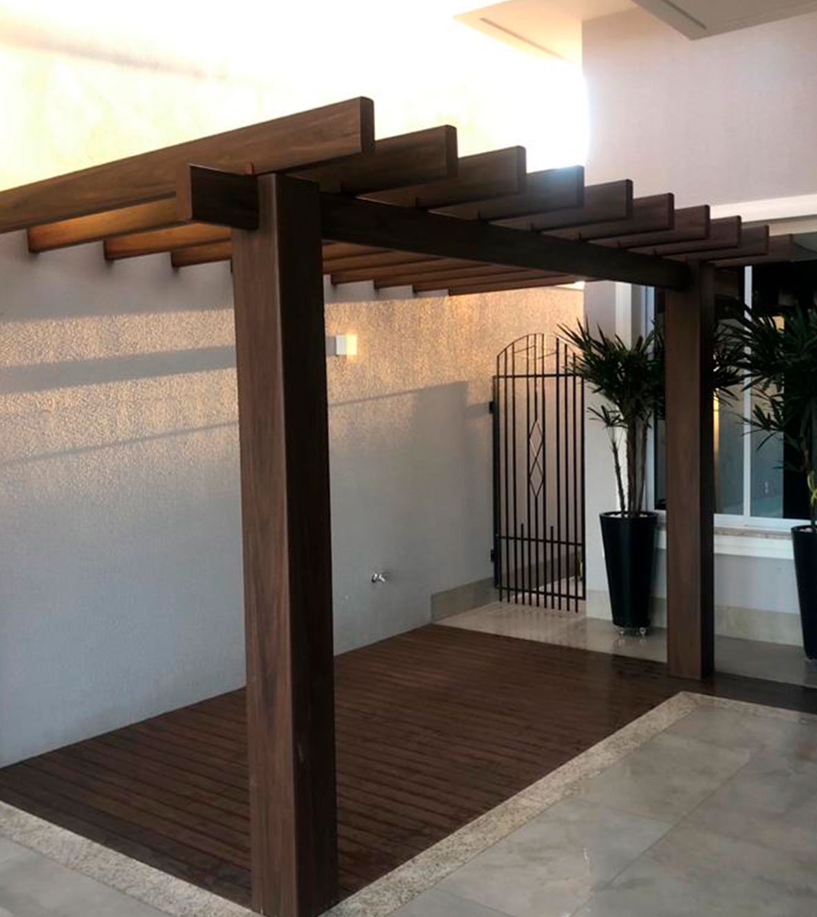 Pergolado Linha Prime em hall de entrada com portão de ferro